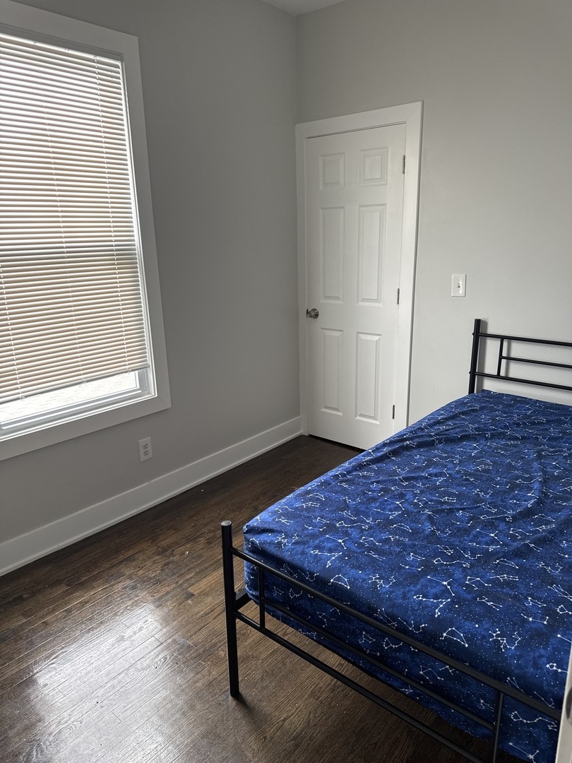 310 West 105th Street Chicago, IL 60628 - Photo 15 of 22 a view of a bedroom with wooden floor and window
