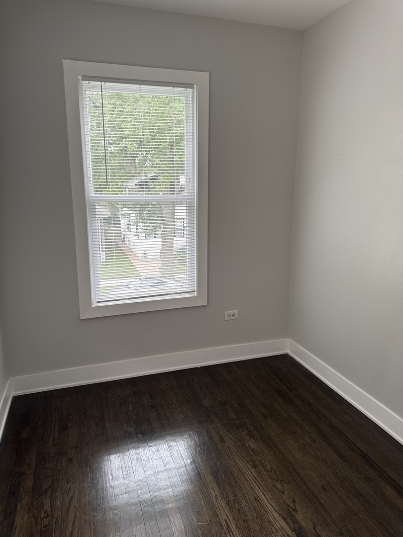310 West 105th Street Chicago, IL 60628 - Photo 7 of 22 an empty room with wooden floor and windows