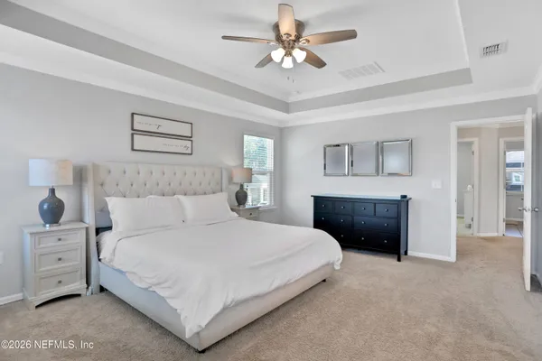 a bedroom with a large bed and a chandelier