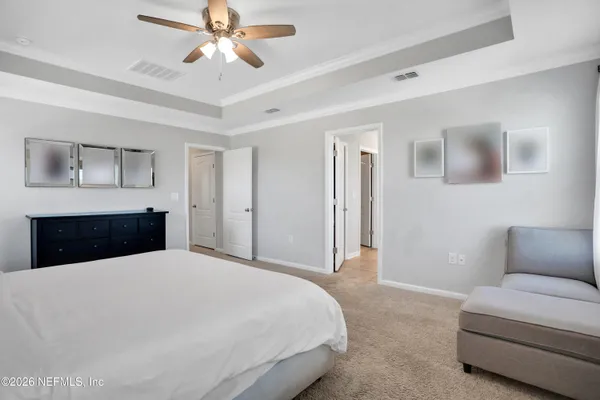 a bedroom with a large bed and a chandelier