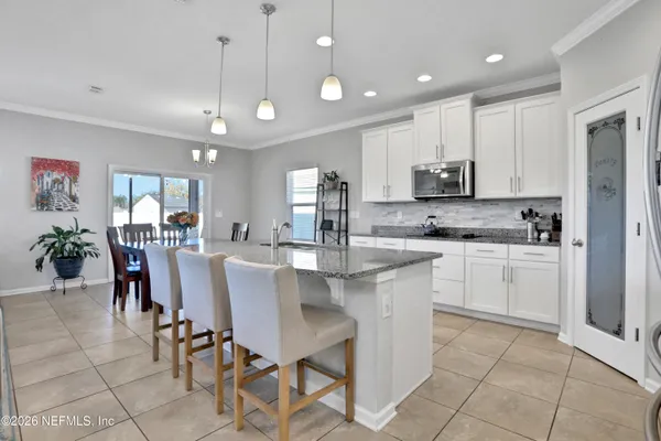 a kitchen with kitchen island granite countertop stainless steel appliances cabinets a sink and a counter top space
