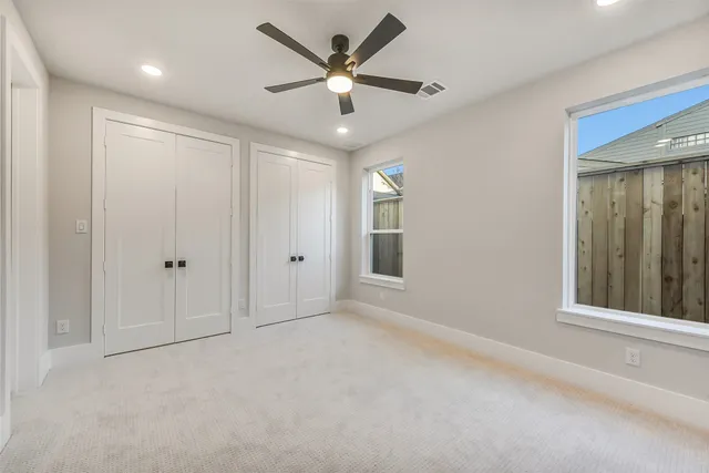an empty room with fan and windows