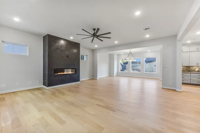 a view of an empty room with a window and a kitchen