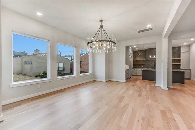 a view of a big room with wooden floor and windows