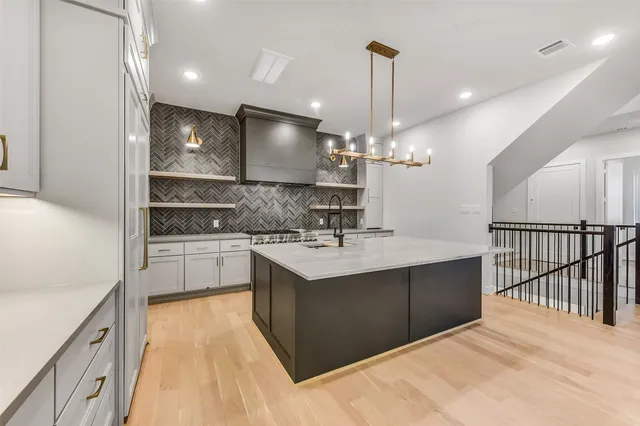 a kitchen with stainless steel appliances granite countertop a sink a stove and a refrigerator