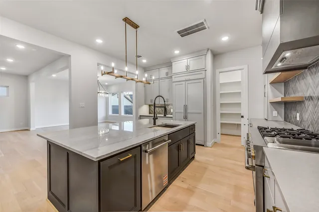 a kitchen with kitchen island a sink stove and refrigerator