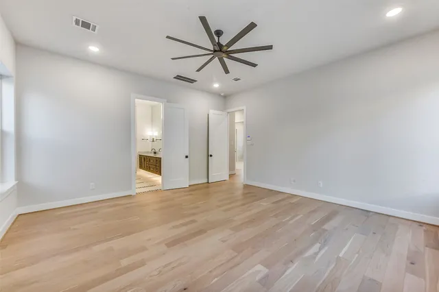 a view of an empty room with cabinet and a ceiling fan
