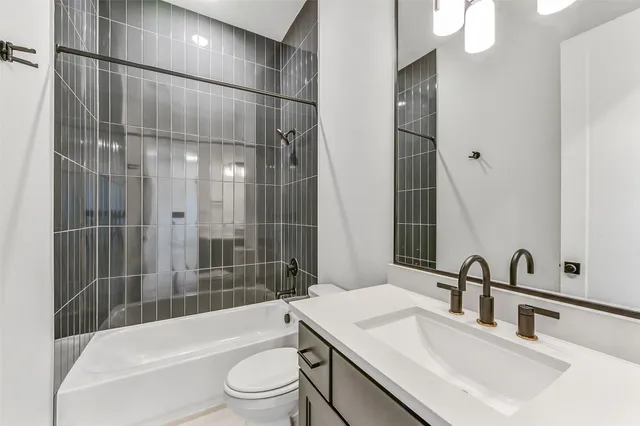 a bathroom with a bathtub shower sink mirror vanity and toilet