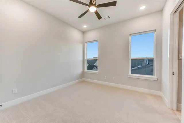 en empty room with window and ceiling fan