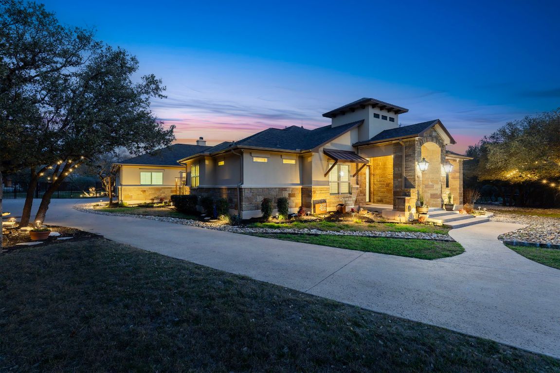Full exterior lighting and landscaping create a serene escape at night