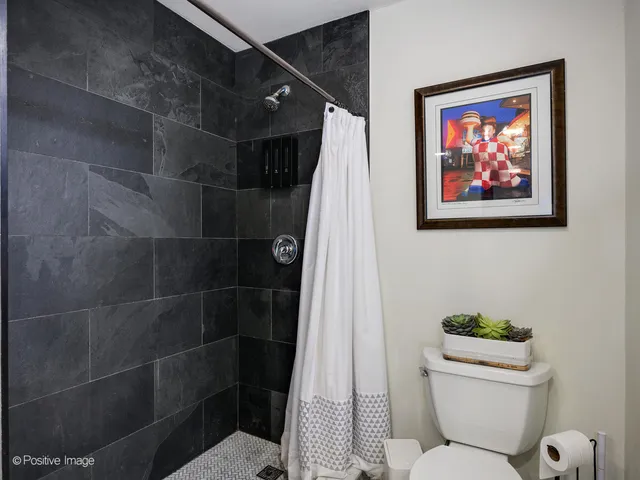 a bathroom with a toilet and a shower