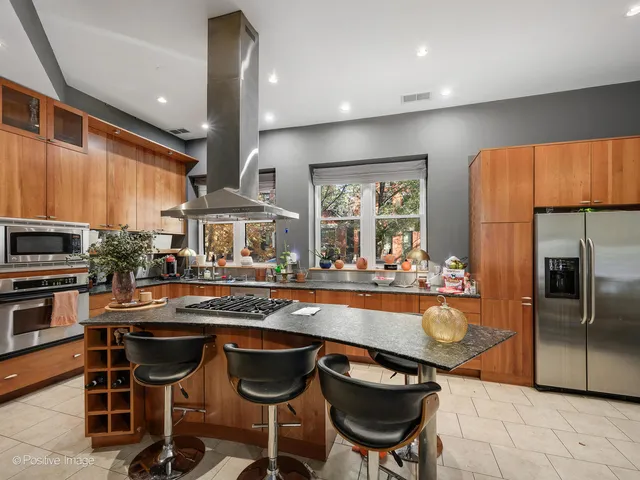 a kitchen with granite countertop a sink and chairs