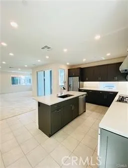a large kitchen with stainless steel appliances a sink and cabinets