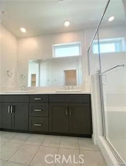 a bathroom with a granite countertop double vanity sink and a mirror