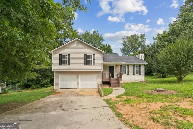 a front view of a house with a garden and trees