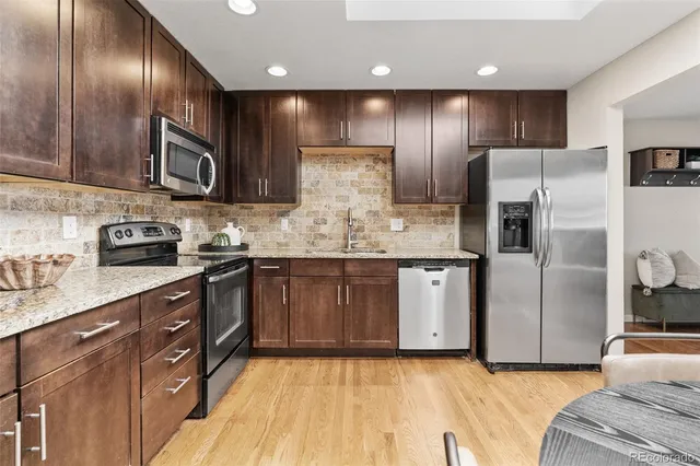a kitchen with stainless steel appliances granite countertop refrigerator a sink a stove and cabinets