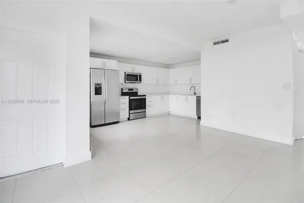 a view of a kitchen with refrigerator and microwave