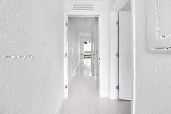 a view of a hallway with wooden floor and closet