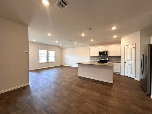 a kitchen with stainless steel appliances granite countertop a sink stove and wooden floor