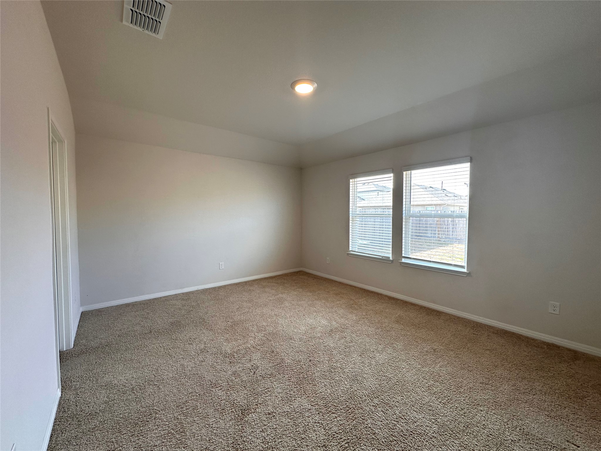 13804 Thomas Wheeler Way Manor, TX 78653 - Photo 16 of 27 Empty room featuring light colored carpet and lofted ceiling