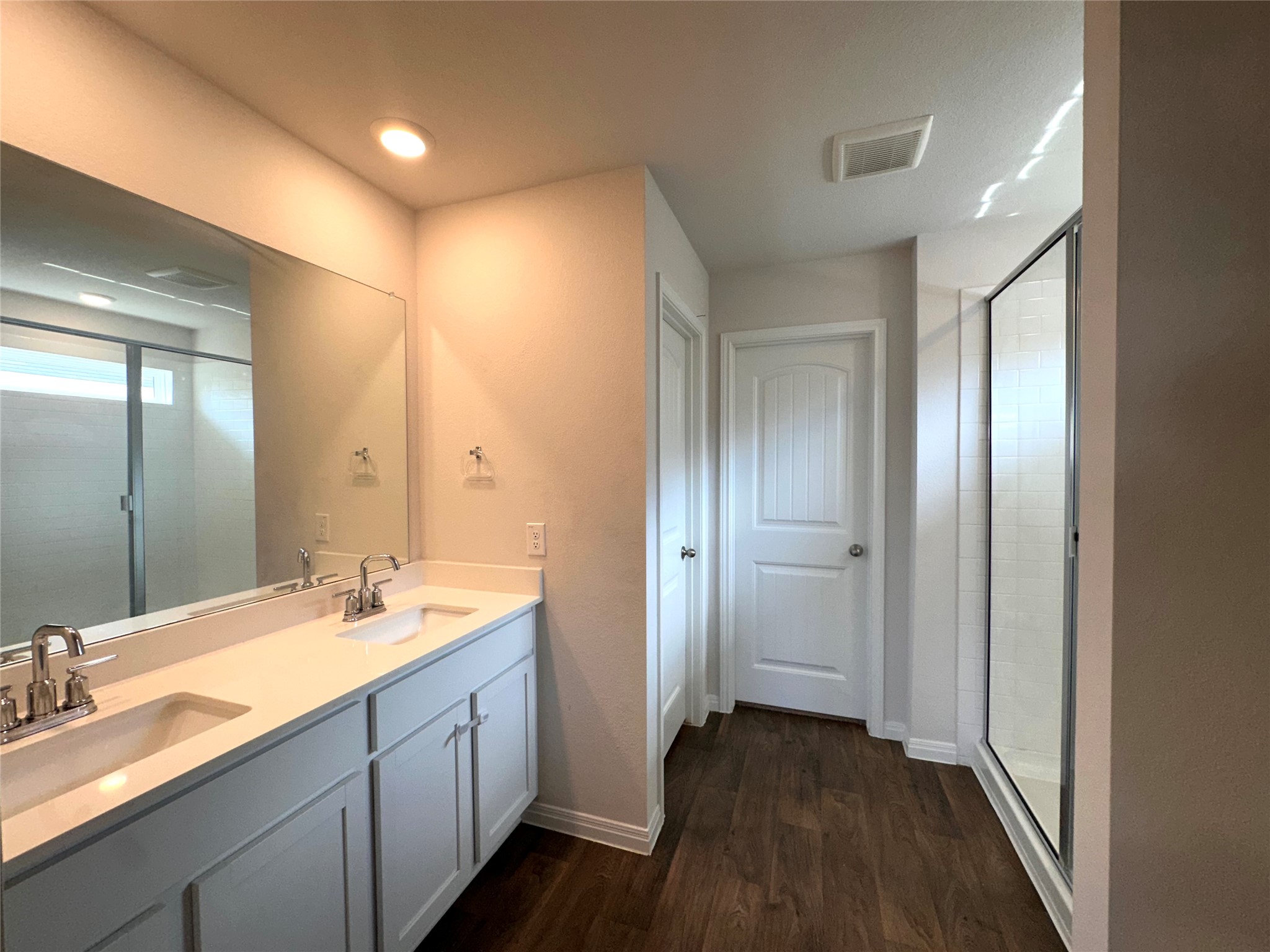 13804 Thomas Wheeler Way Manor, TX 78653 - Photo 18 of 27 Full bathroom featuring a stall shower, double vanity, dark wood-style floors, and recessed lighting