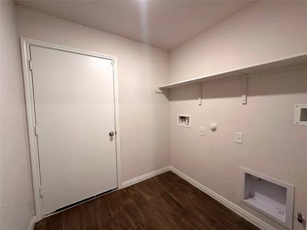 a view of an empty room with wooden floor and entryway