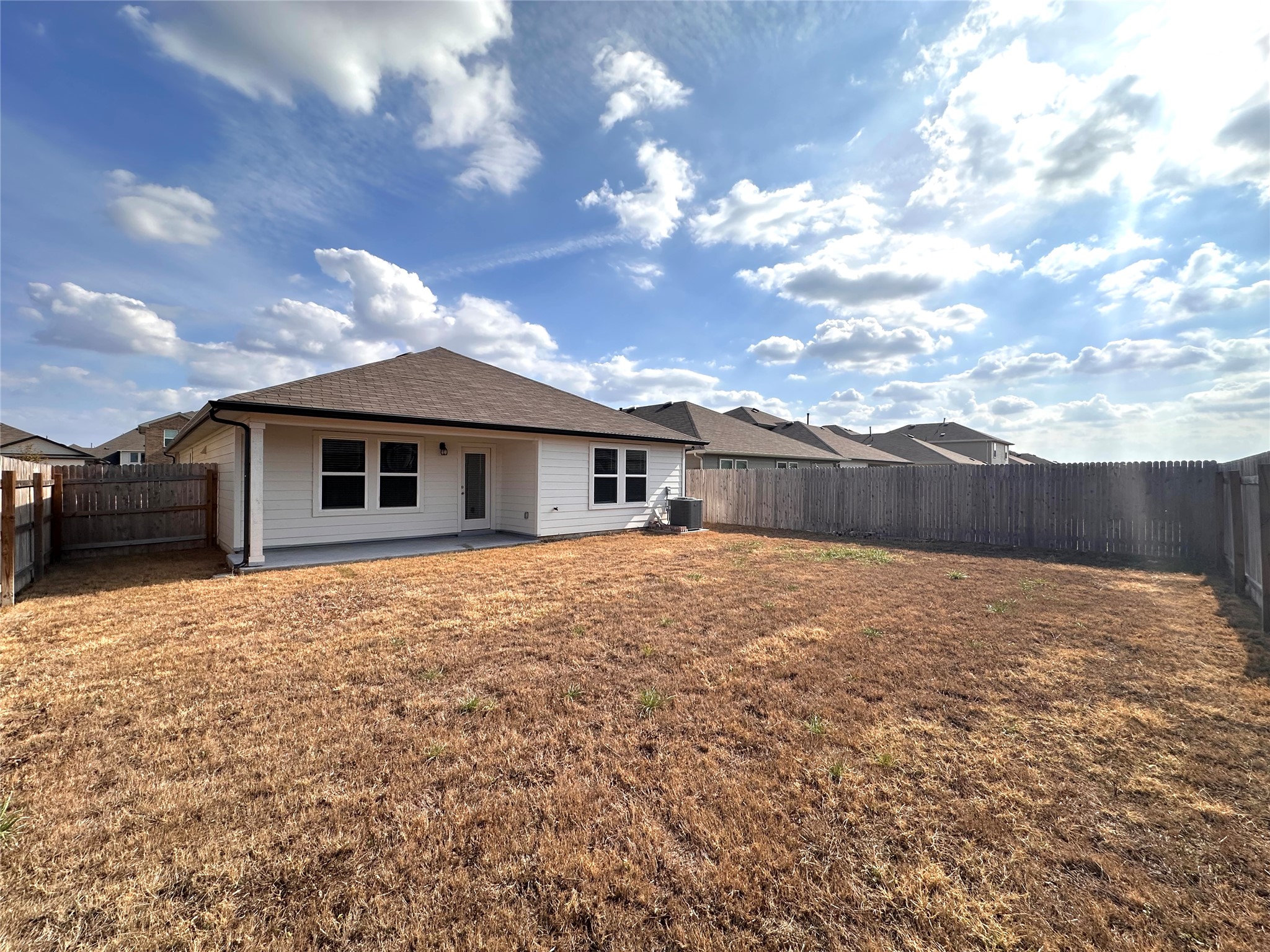 13804 Thomas Wheeler Way Manor, TX 78653 - Photo 25 of 27 Back of house with a patio and a fenced backyard