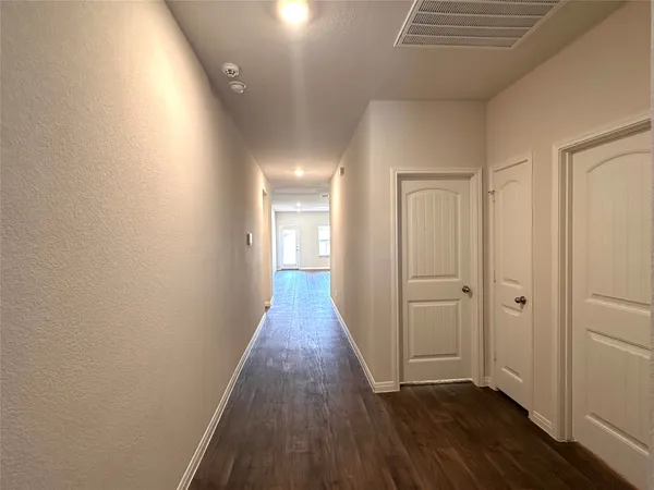a view of a hallway with wooden floor