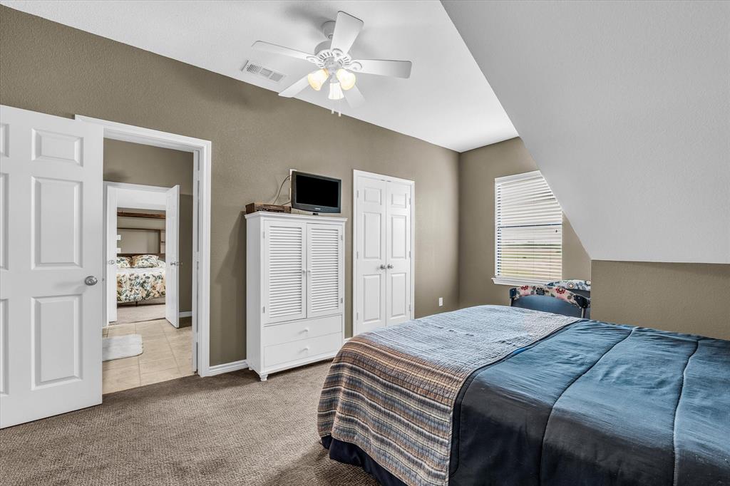 613 Bone Road Valley Mills, TX 76689 - Photo 16 of 40 a bedroom with a large bed and a chandelier
