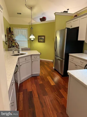 a kitchen with a refrigerator sink and cabinets