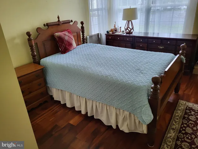a bedroom with bed and wooden floor