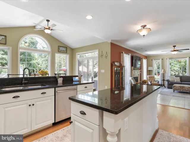 a kitchen with stainless steel appliances granite countertop a stove a sink a microwave a dining table and chairs