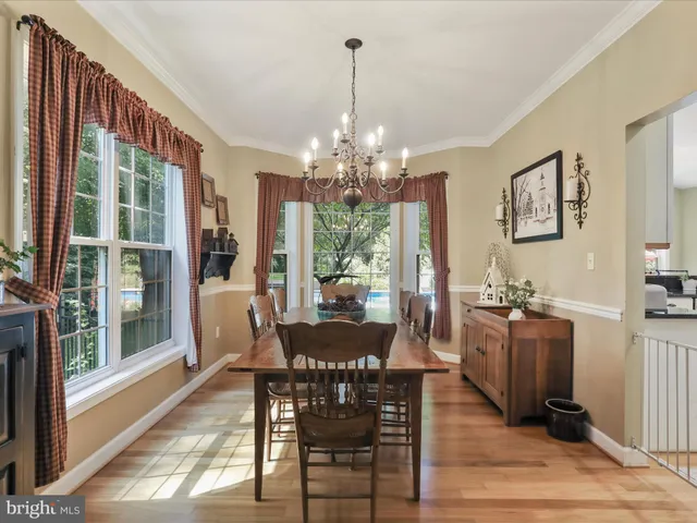 a view of a dining room with furniture a chandelier and wooden floor