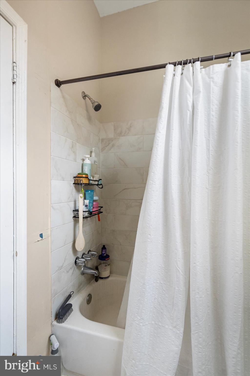 2304 Eutaw Place Baltimore, MD 21217 - Photo 17 of 105 a bath tub sitting next to a white sink and a shower
