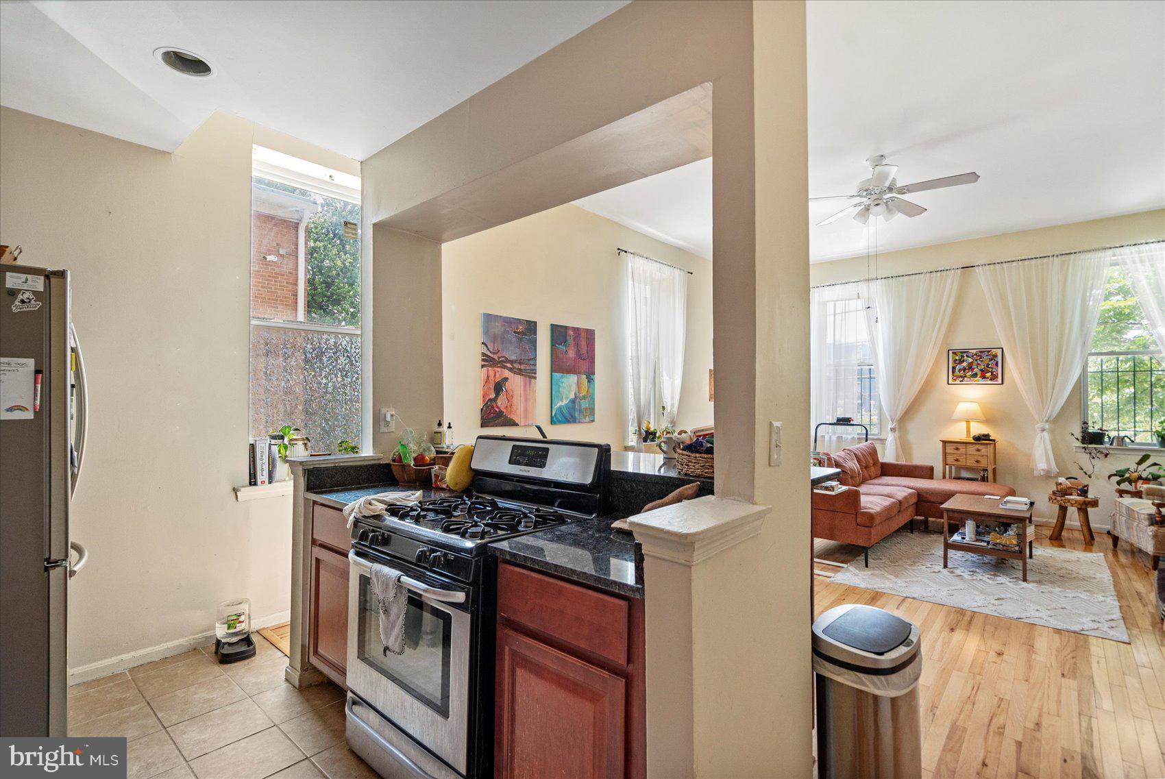2304 Eutaw Place Baltimore, MD 21217 - Photo 24 of 105 a kitchen with stainless steel appliances granite countertop a stove a sink dishwasher and a dining table with wooden floor