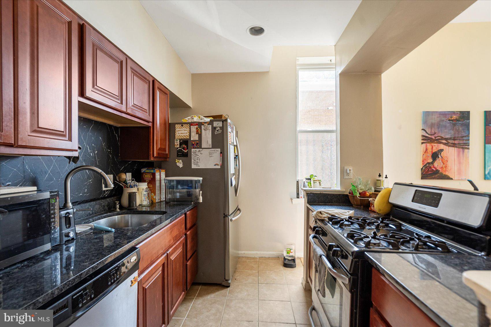 2304 Eutaw Place Baltimore, MD 21217 - Photo 25 of 105 a kitchen with stainless steel appliances a stove sink microwave and cabinets