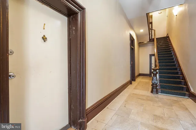 a living room with furniture a potted plant and a wooden floor