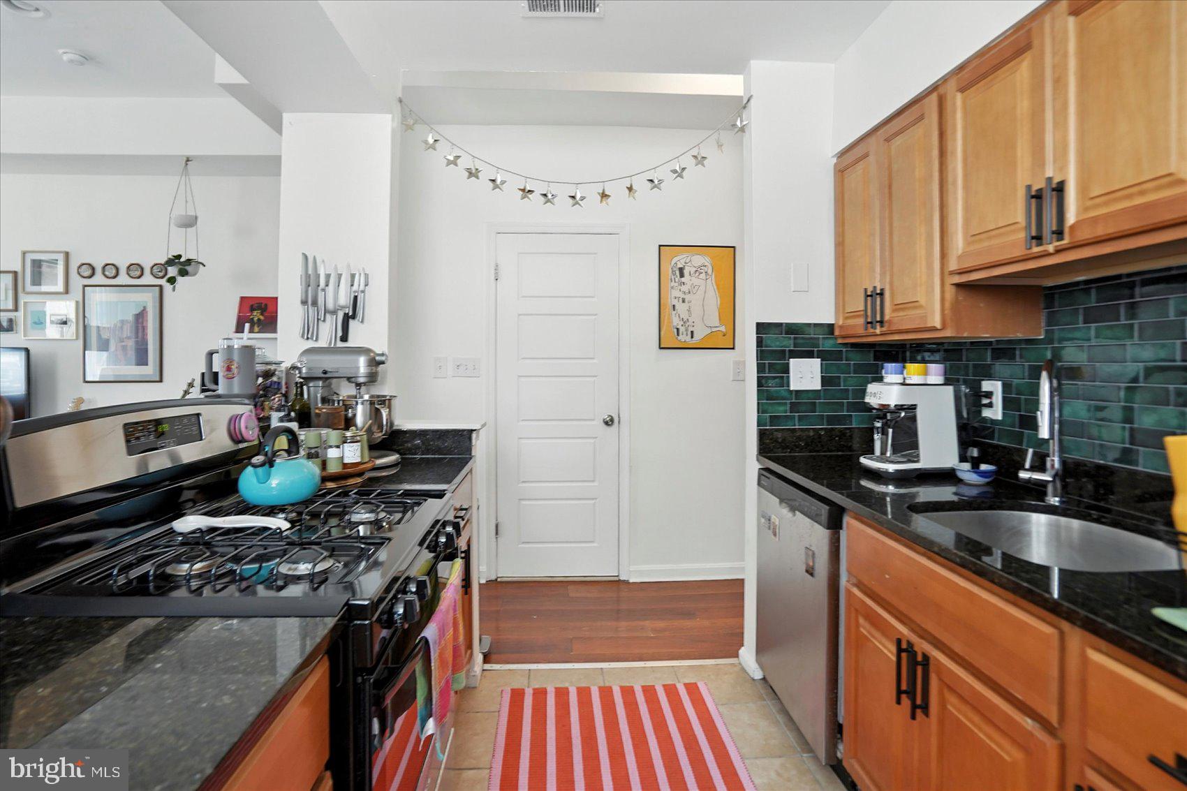 2304 Eutaw Place Baltimore, MD 21217 - Photo 51 of 105 a kitchen with stainless steel appliances a stove a sink and a microwave