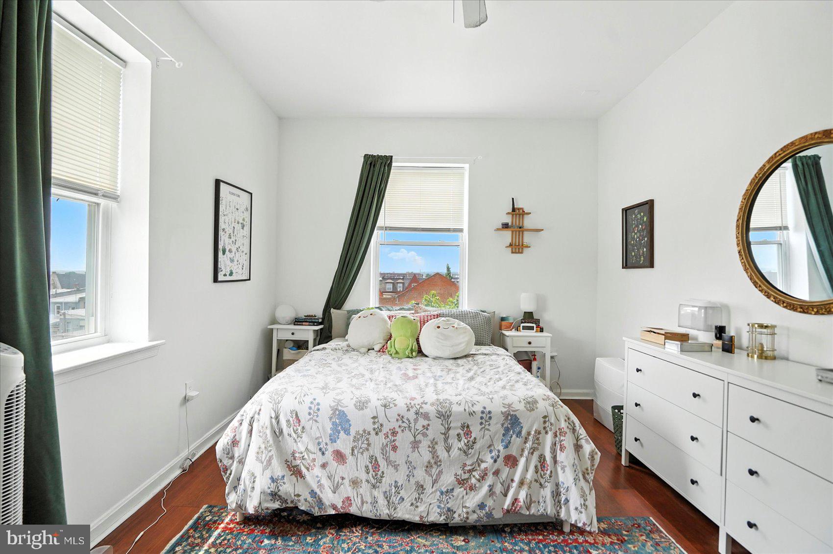 2304 Eutaw Place Baltimore, MD 21217 - Photo 59 of 105 a bedroom with a bed a mirror on the dresser and a window