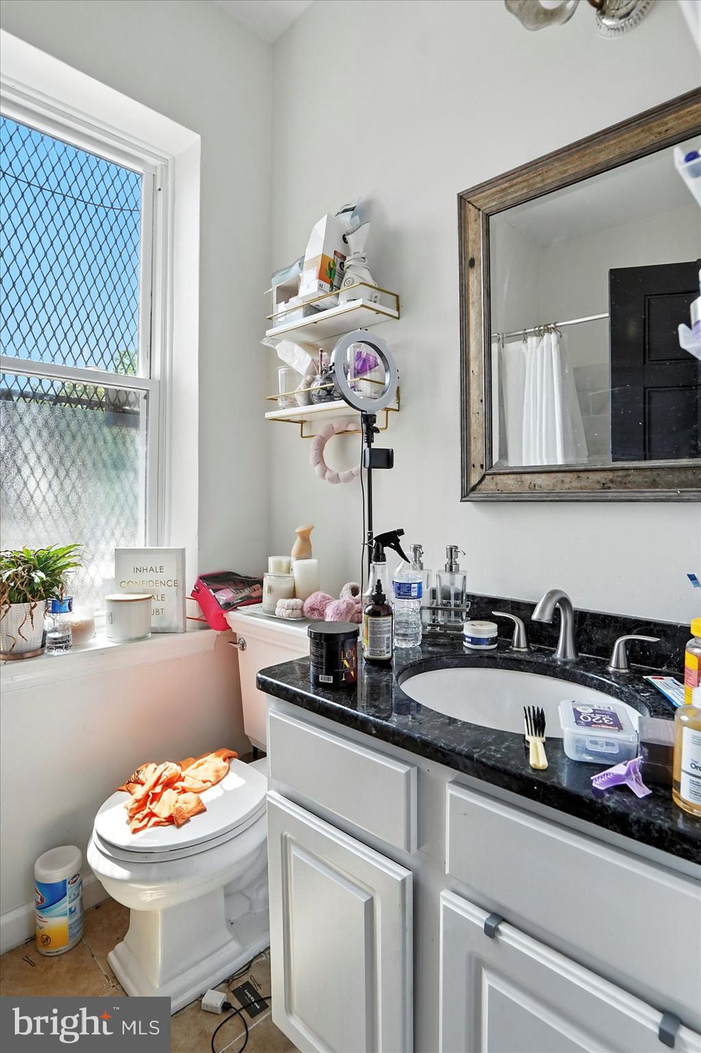 2304 Eutaw Place Baltimore, MD 21217 - Photo 79 of 105 a bathroom with a sink mirror and toilet