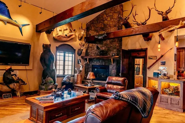 a living room with furniture a flat screen tv and floor to ceiling window