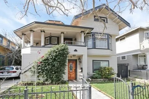 a view of a white house with large windows and a table and chairs