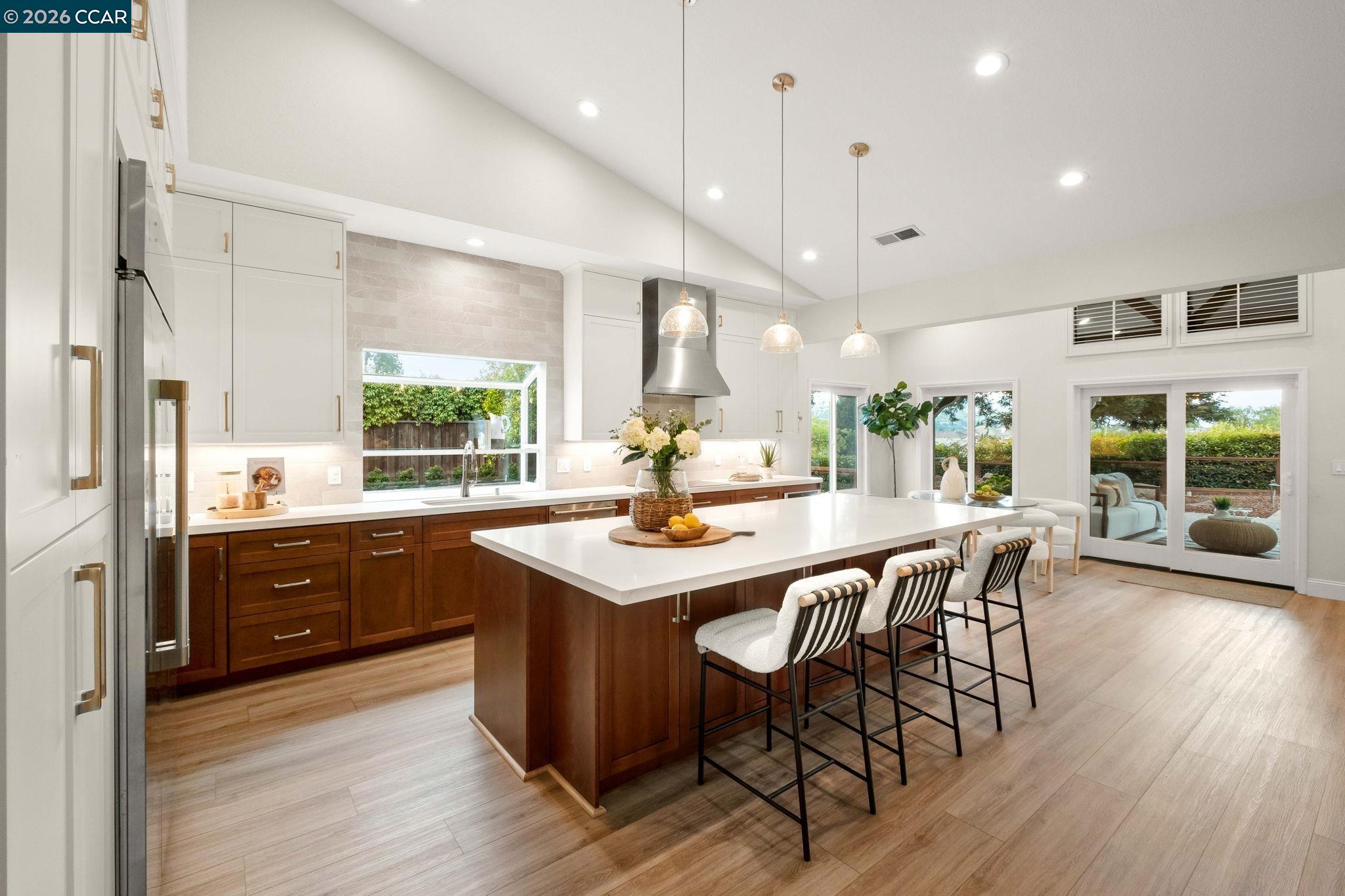 76 Rock Ridge Court Danville, CA 94526 - Photo 14 of 65 a kitchen with stainless steel appliances granite countertop a table chairs stove and wooden floor