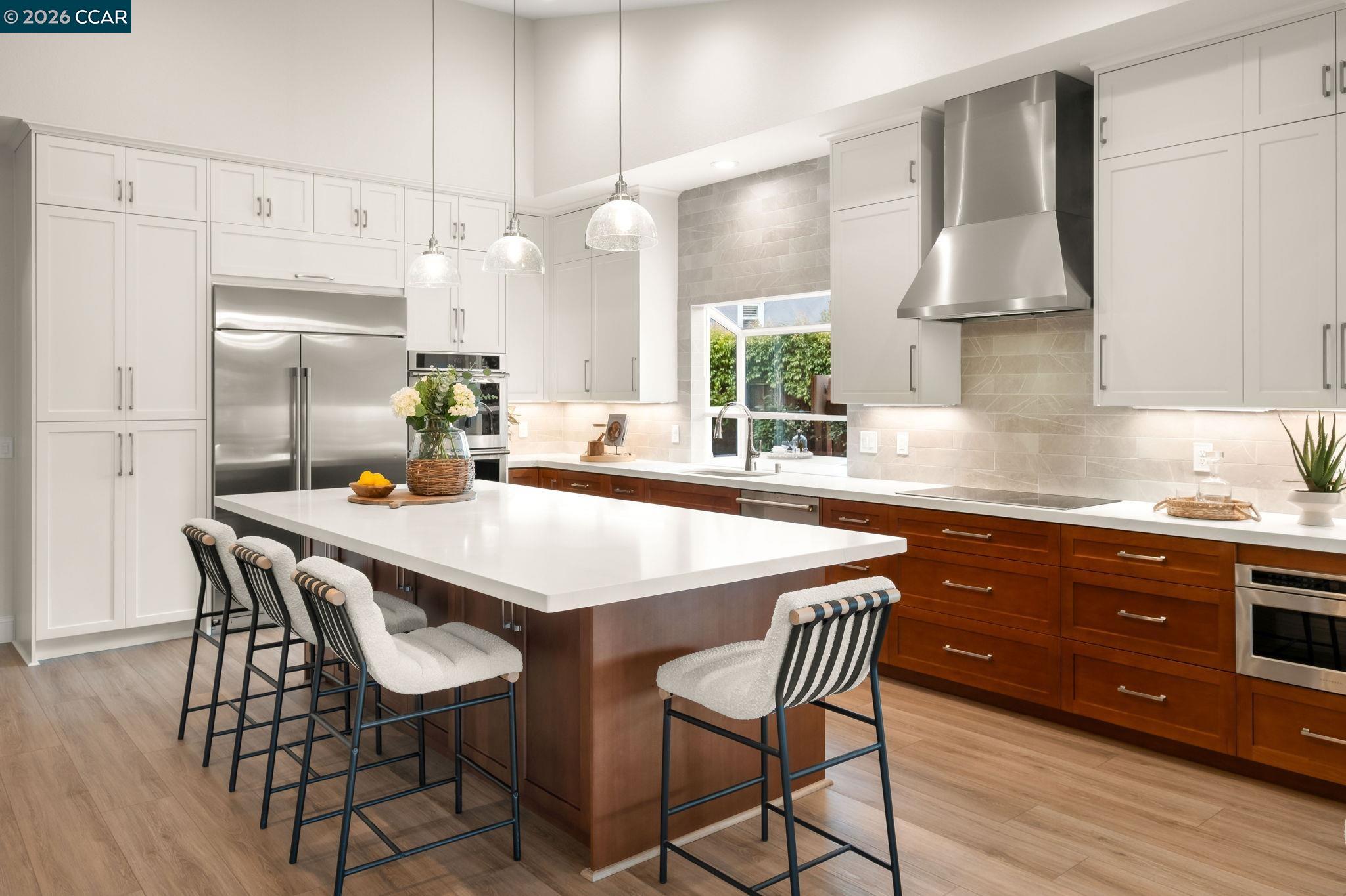 76 Rock Ridge Court Danville, CA 94526 - Photo 21 of 65 a kitchen with stainless steel appliances a dining table chairs and white cabinets