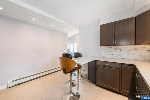 a kitchen with granite countertop a sink cabinets and stainless steel appliances