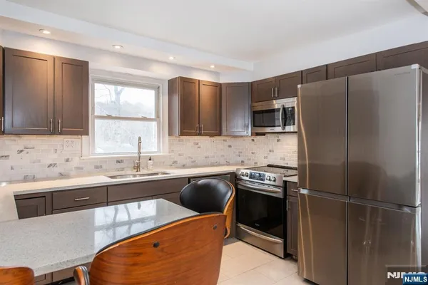 a kitchen with a sink a refrigerator and a stove top oven