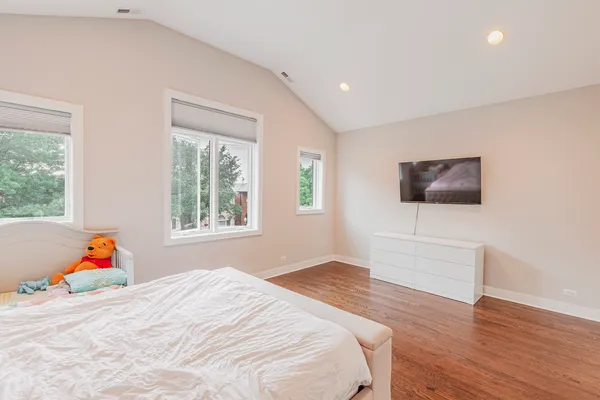 a bedroom with a bed and wooden floor