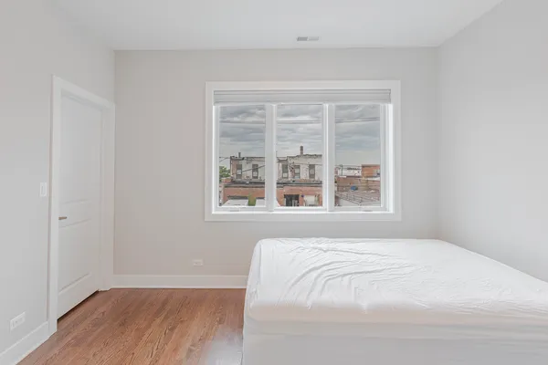 a large bed sitting in a bedroom next to a window