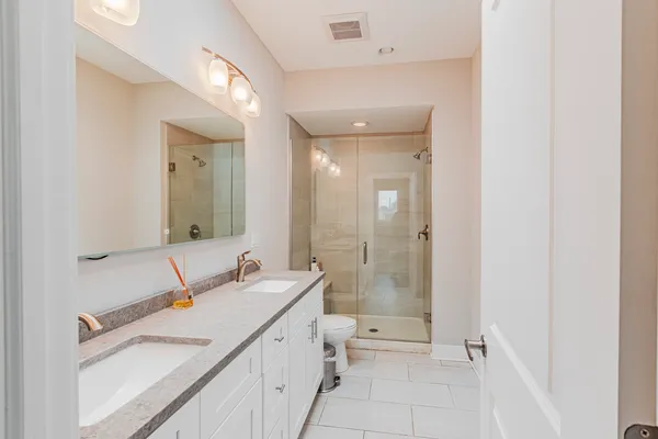 a bathroom with a double vanity sink mirror and shower
