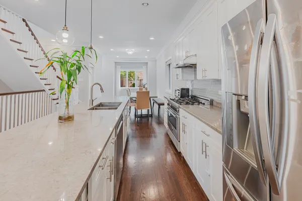 a kitchen with stainless steel appliances a stove a refrigerator a oven a sink a counter top space and cabinets